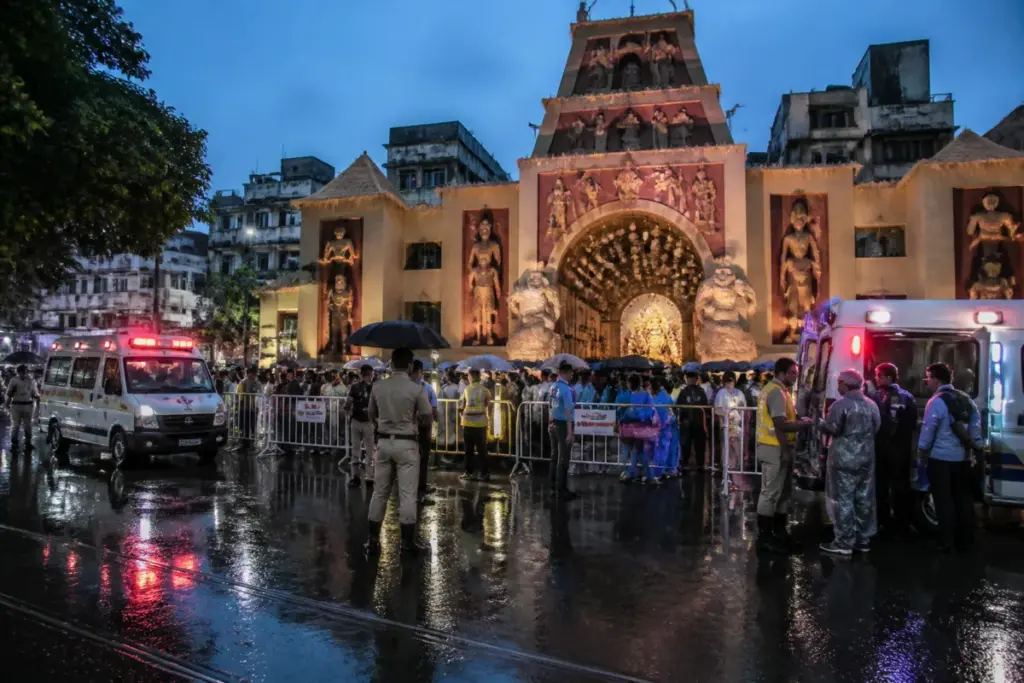 Kolkata Durga Puja pandal with crowds and emergency response after a reported stampede