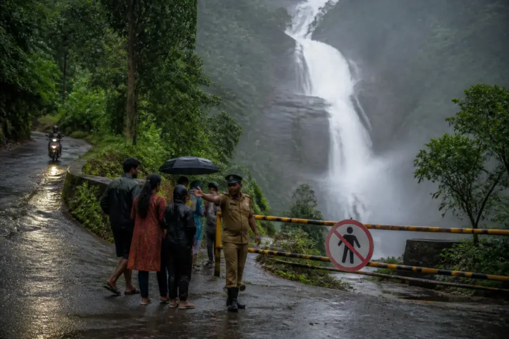 Kerala Tourism rain alerts prompt restrictions near a waterfall and landslide-prone road.