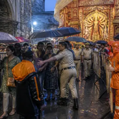 Crowd outside a Kolkata Durga Puja pandal after a reported stampede during rain