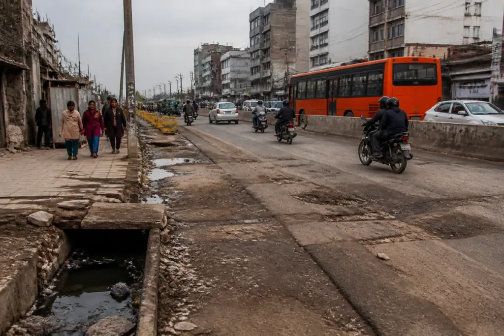 Damaged Rohtak Road in Delhi marked for recarpeting after utility work and road deterioration.
