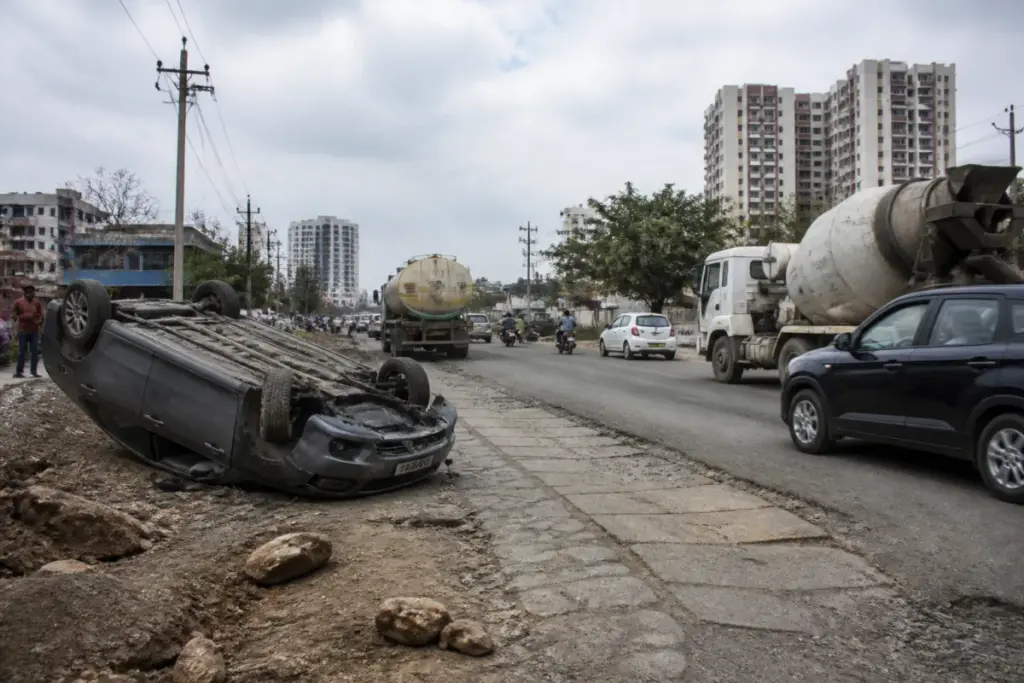 Damaged Pune Undri Road near The Corinthians Club with traffic moving along cracked asphalt