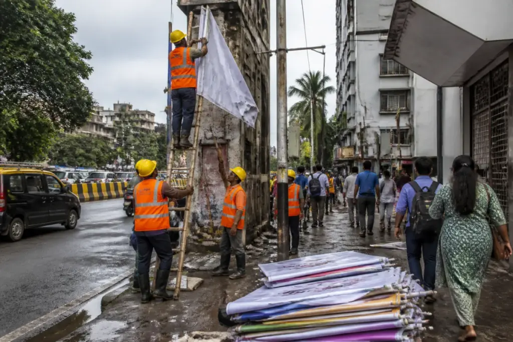 BMC workers remove illegal banners in Mumbai from a public street
