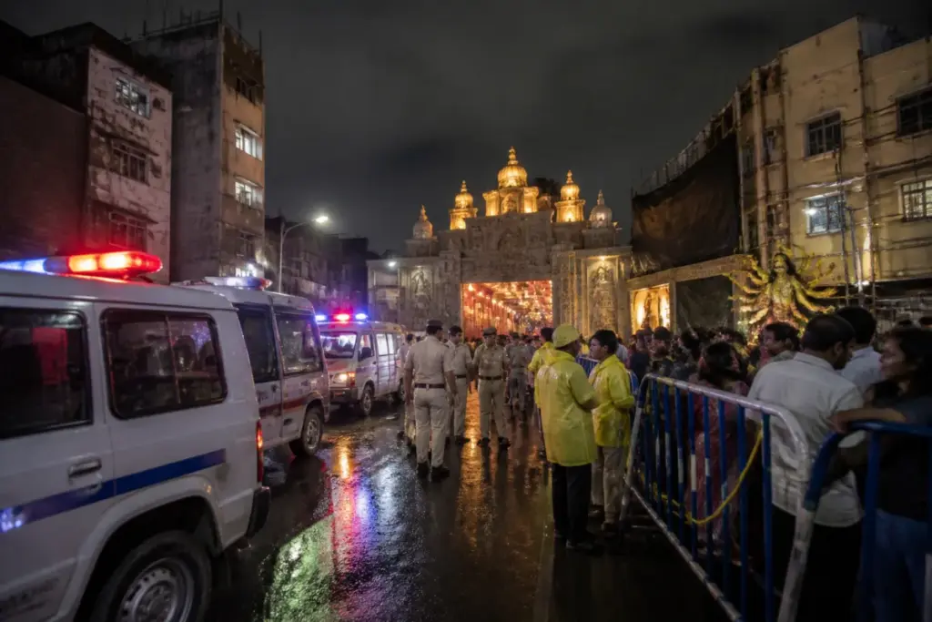 Kolkata puja stampede aftermath near a crowded pandal and emergency responders