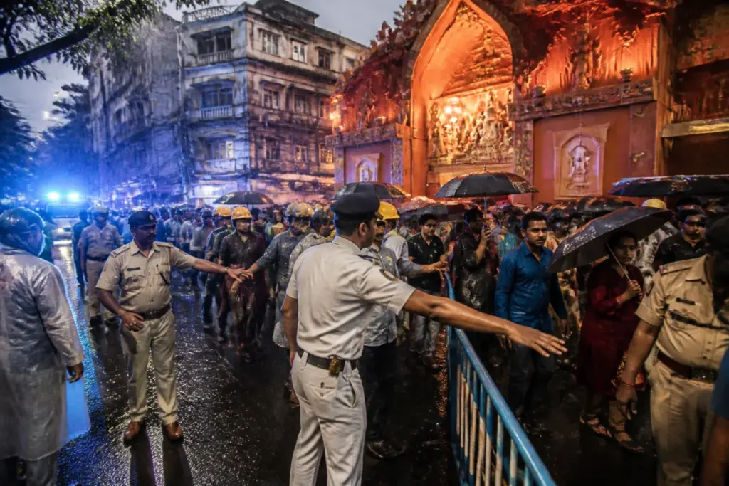 Kolkata Durga Puja stampede scene near a crowded pandal during rain