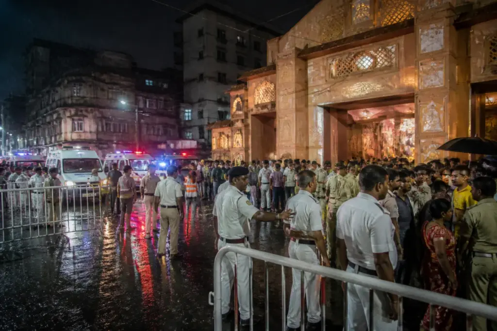 Kolkata Durga Puja stampede site with police and emergency workers outside a crowded pandal
