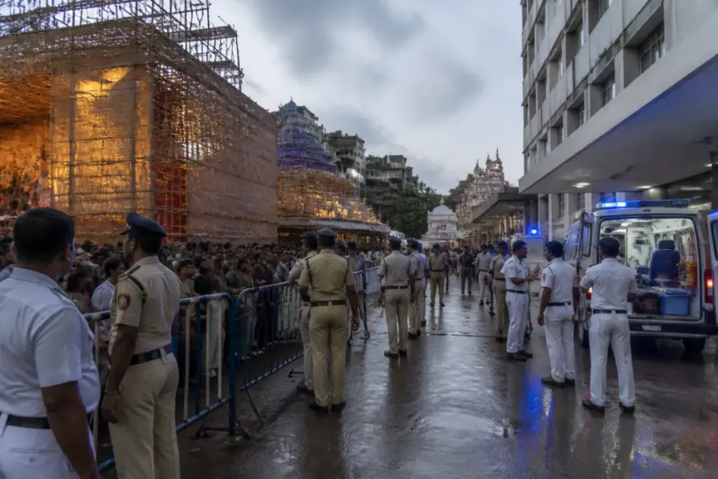 Kolkata puja stampede site with emergency responders and a crowded temporary festival venue