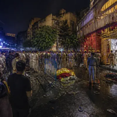 Kolkata puja stampede site with a crowded Durga Puja pandal entrance and emergency response