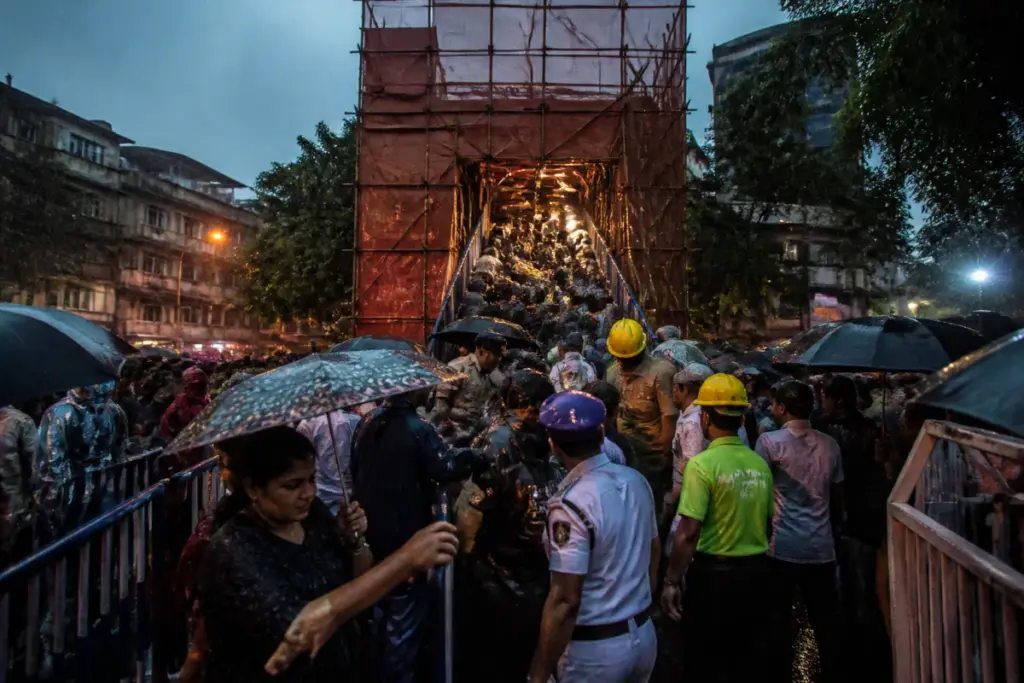 Kolkata pandal stampede aftermath near a crowded Durga Puja structure in heavy rain