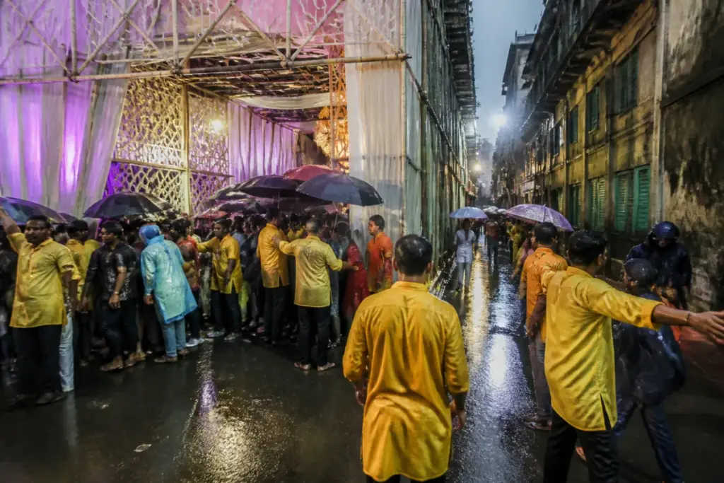 Crowded Kolkata Durga Puja pandal entrance during rain, highlighting crowd safety risks