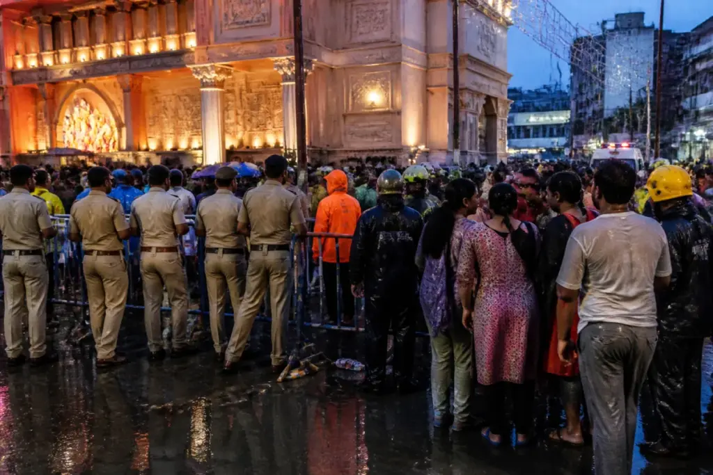 Kolkata pandal stampede site with barricades and crowds near a rain-hit Durga Puja venue