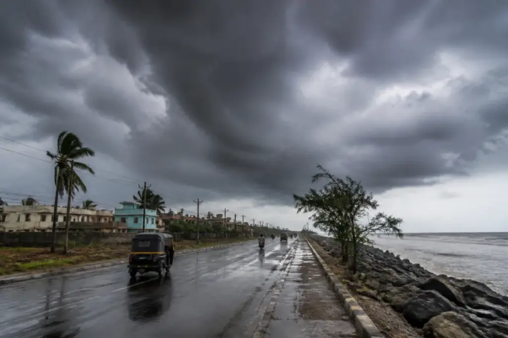 Dark rain clouds over an Odisha coastal road during a possible low-pressure weather system