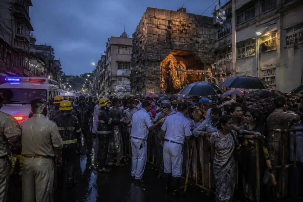 Kolkata Chorbagan stampede site with rain-soaked festival crowds and emergency response activity