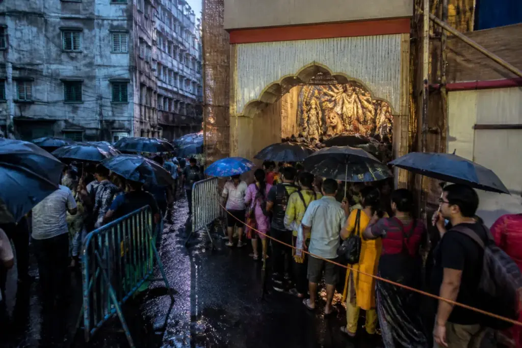 Kolkata stampede site with a crowded Durga Puja pandal entrance after rain