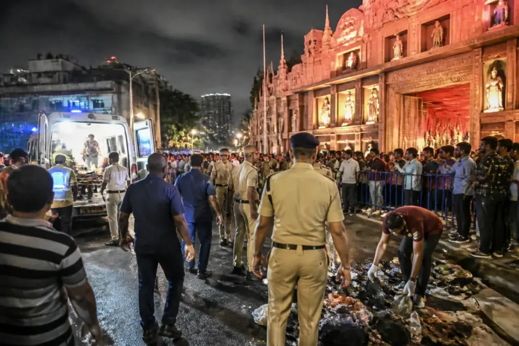 Crowd-control barriers and emergency response near a Kolkata puja pandal after the Chorbagan stampede