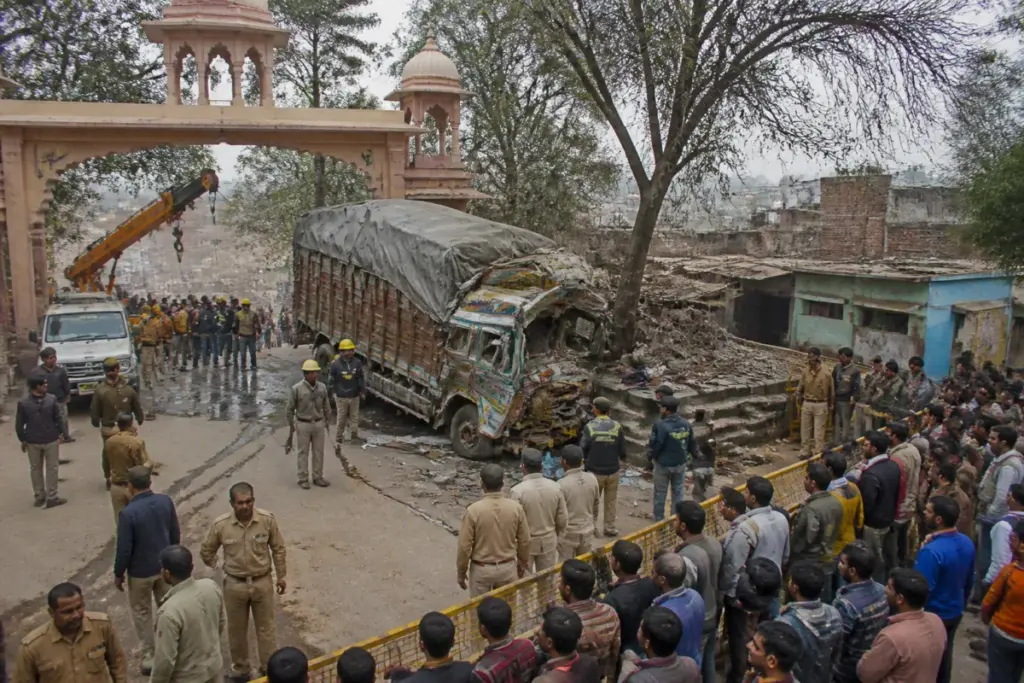 Gwalior temple crash site near Sheetla Mata Temple with emergency vehicles and crowd-control barricades
