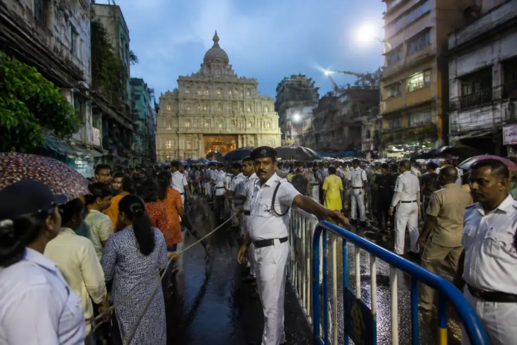 Kolkata stampede aftermath near a crowded Durga Puja pandal with police and barricades