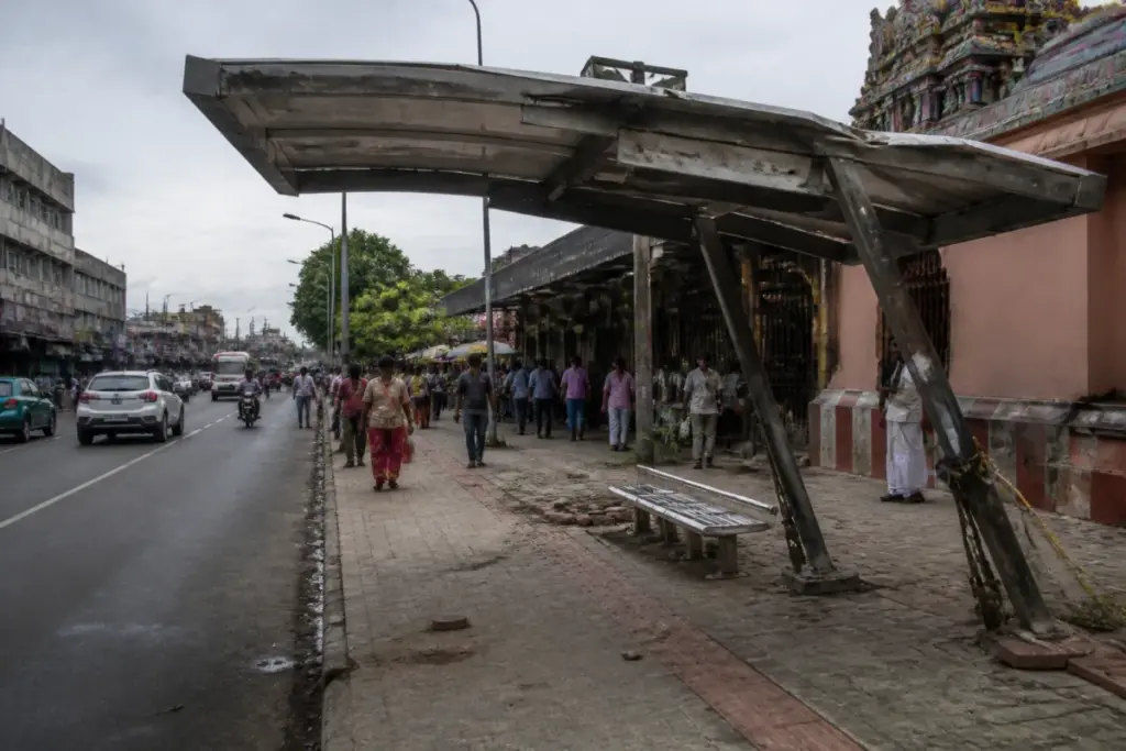 Damaged Chennai bus shelter with leaning pillars and ropes on Kodambakkam High Road