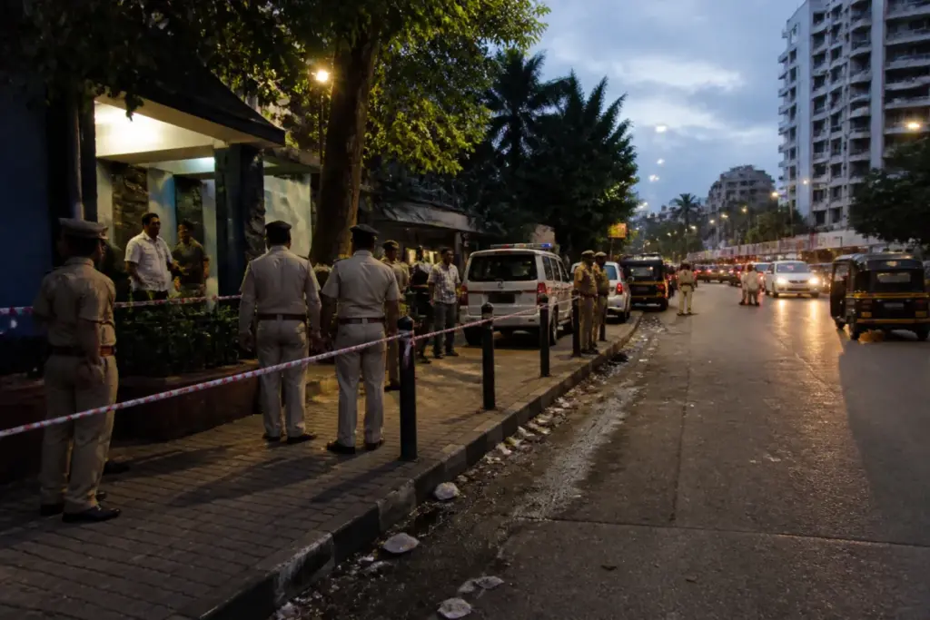 Mumbai shooting investigation near Juhu, with police vehicles and a busy urban road