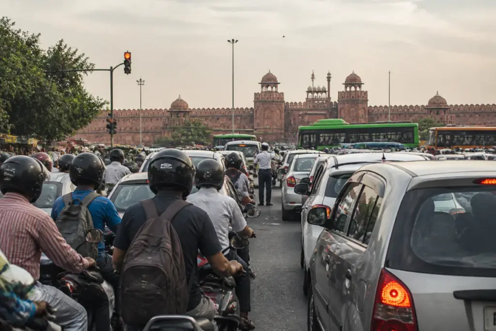 Delhi road noise at a congested junction with vehicles and pedestrians near the Red Fort