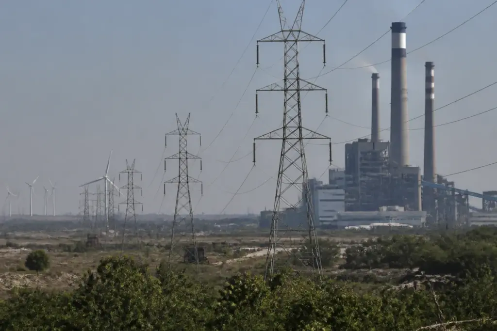 Gujarat power crisis represented by an industrial power plant and electricity transmission lines