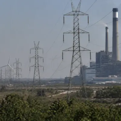 Gujarat power crisis represented by an industrial power plant and electricity transmission lines