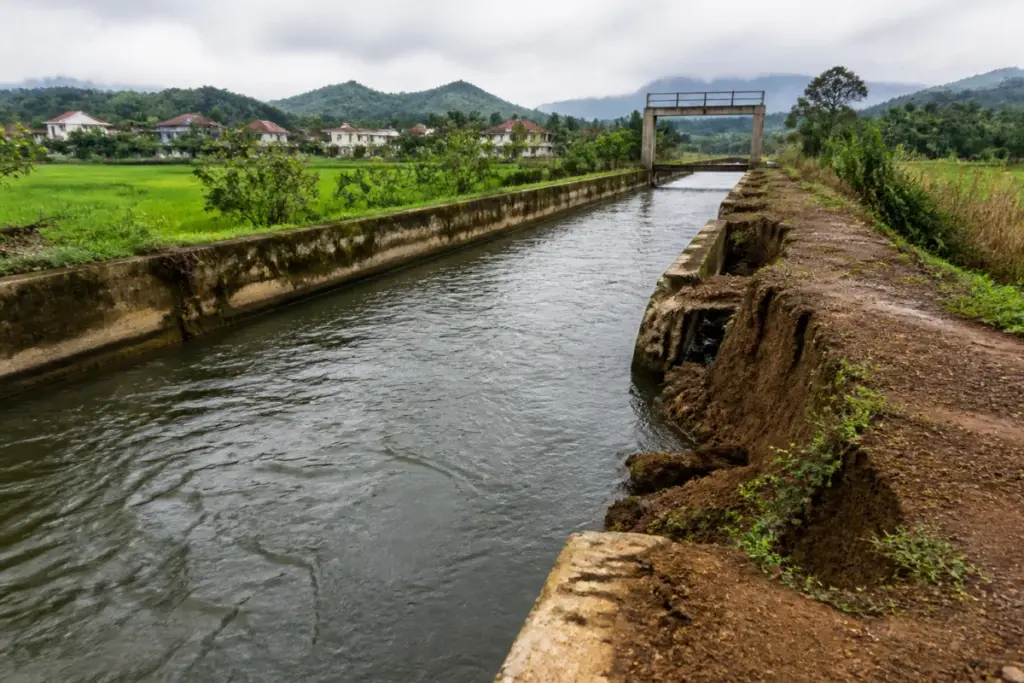Chalakudy canal water supply network with ageing canal walls and flowing irrigation water in Kerala