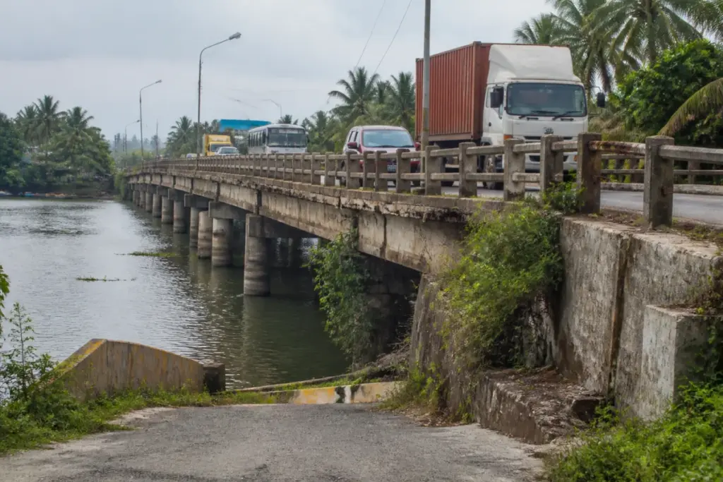 Deteriorating Cherai Bridge in Kerala with damaged concrete and exposed reinforcement bars