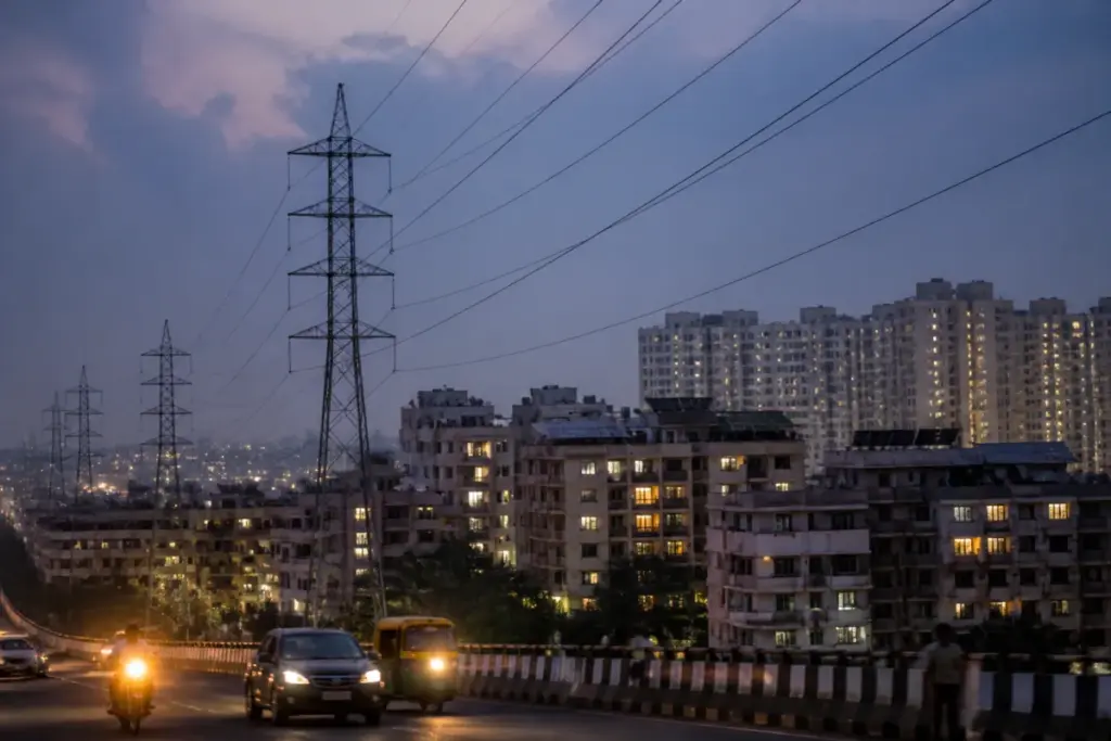 Karnataka power supply infrastructure with electricity lines and Bengaluru homes at dusk