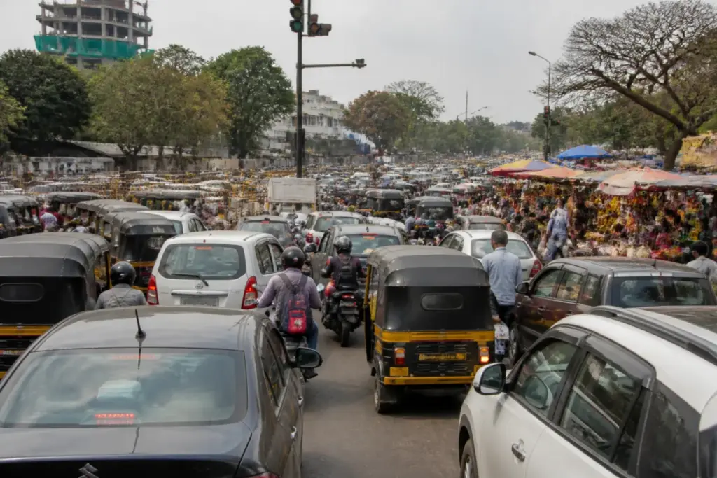 Congested Pune road with vehicles parked irregularly and heavy traffic during daytime