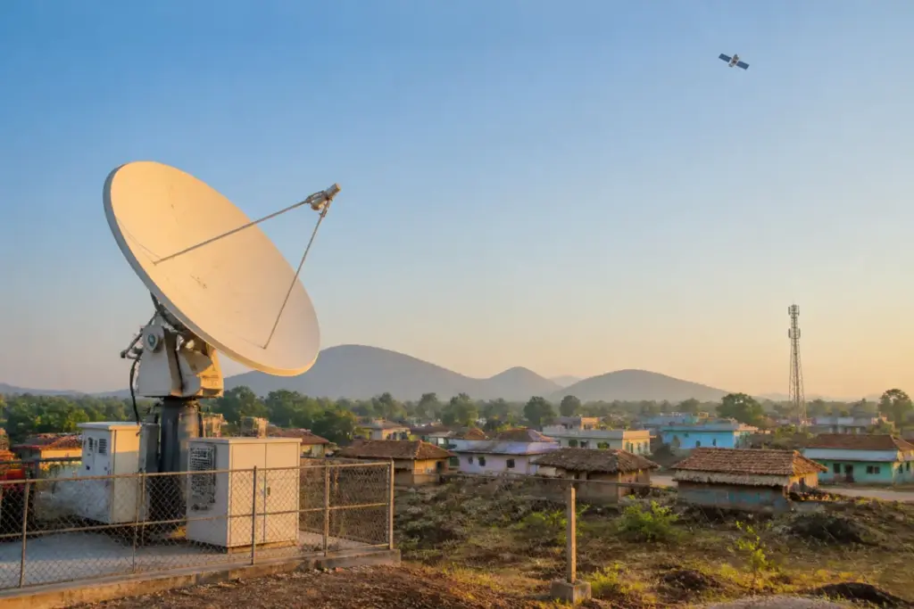 Jio satellite broadband concept over a remote Indian settlement with a ground station