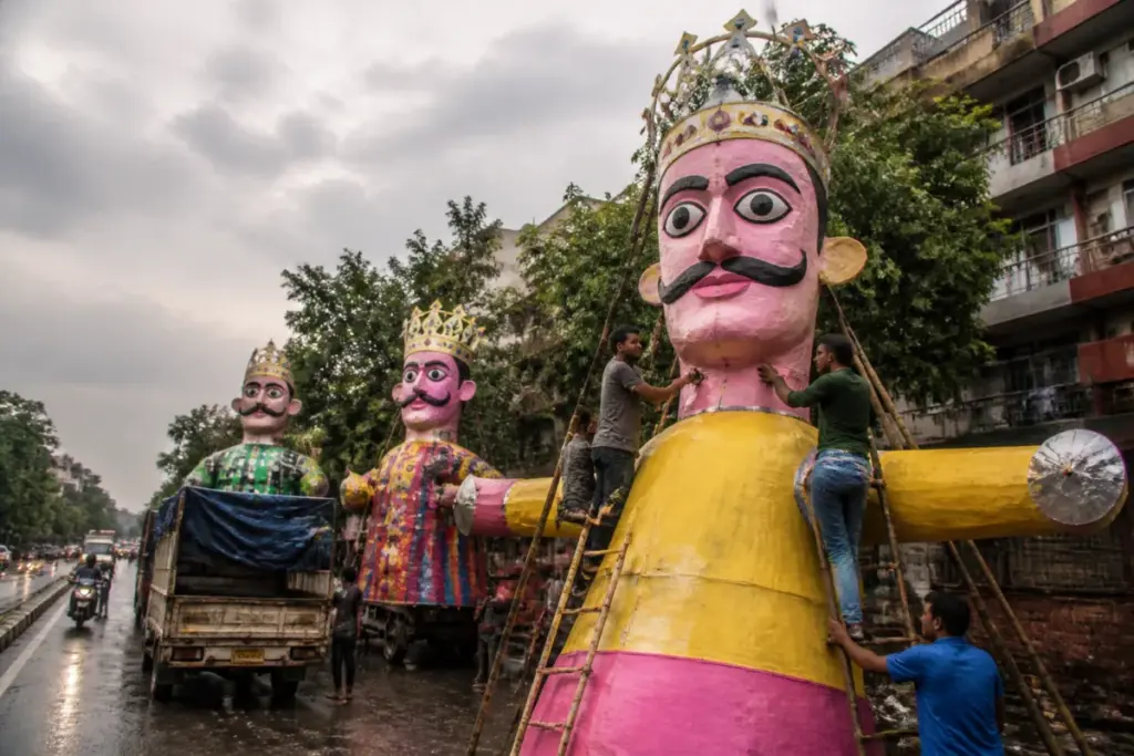 Delhi Dussehra effigies lined along a pavement after rain near Rajouri Garden