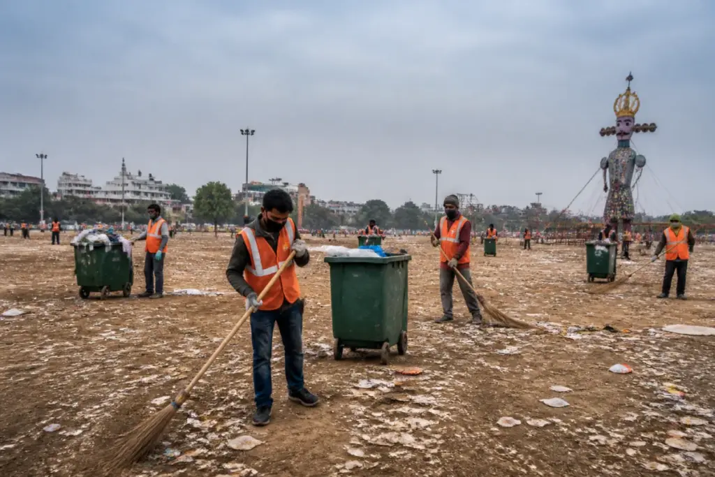 Delhi MCD sanitation workers cleaning a Ramlila ground after Dussehra celebrations