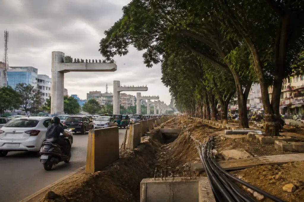 Hyderabad flyover construction corridor with mature trees along the Allwyn-Miyapur road