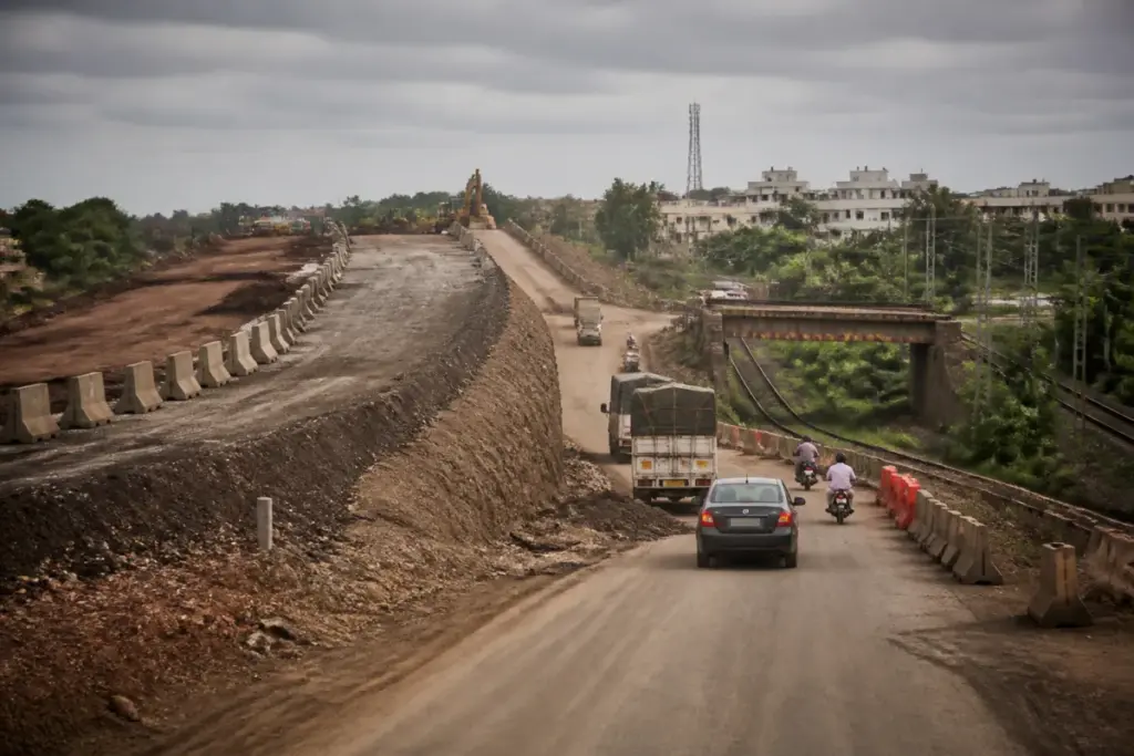Indapur bypass construction and unfinished Mumbai-Goa Highway road near a railway bridge