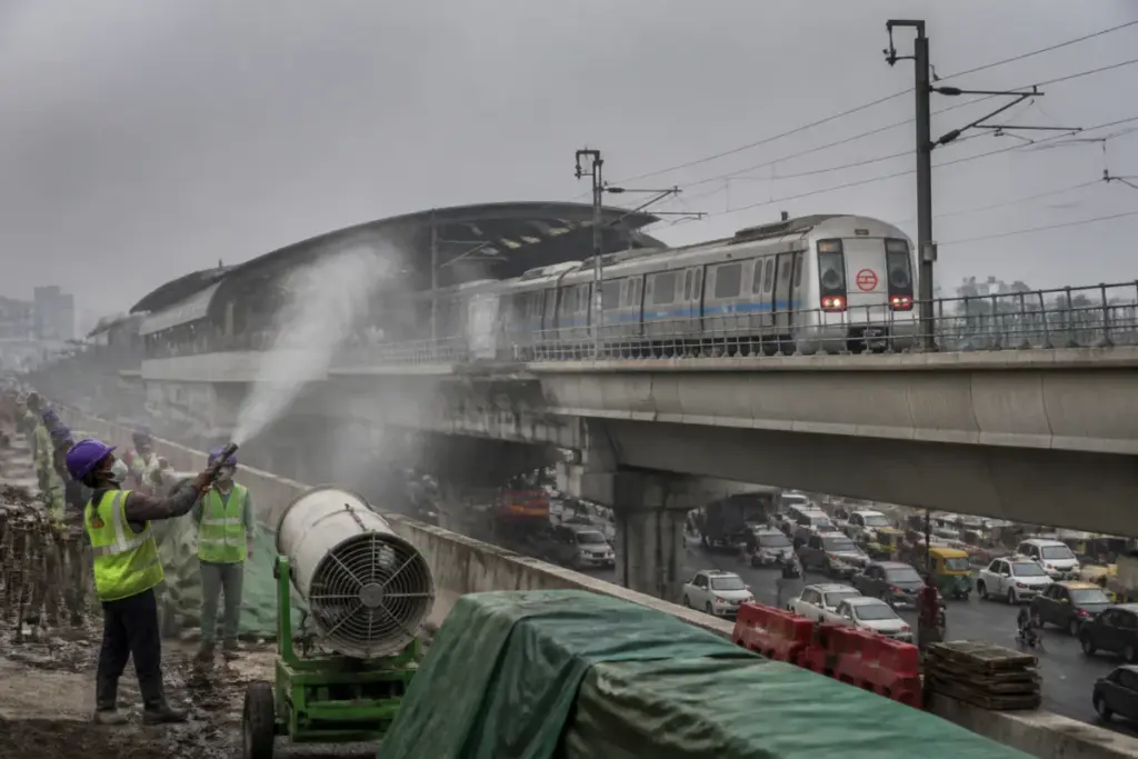 Delhi Metro train and construction-site dust-control equipment during GRAP-1 measures