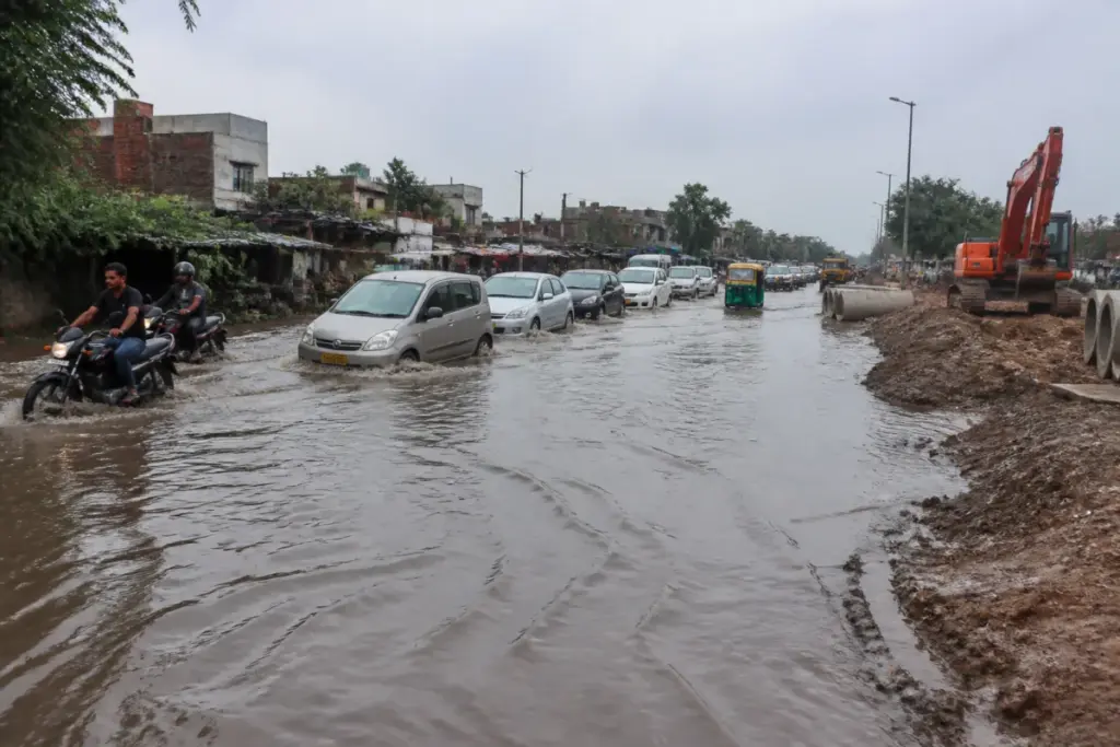 Delhi waterlogging on a flooded Chhatarpur road during monsoon rain