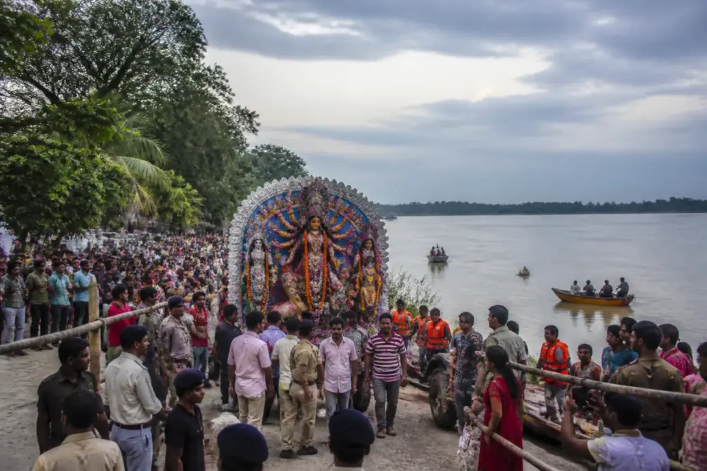 Dibrugarh Durga Puja immersion procession near the Brahmaputra with crowds and safety teams