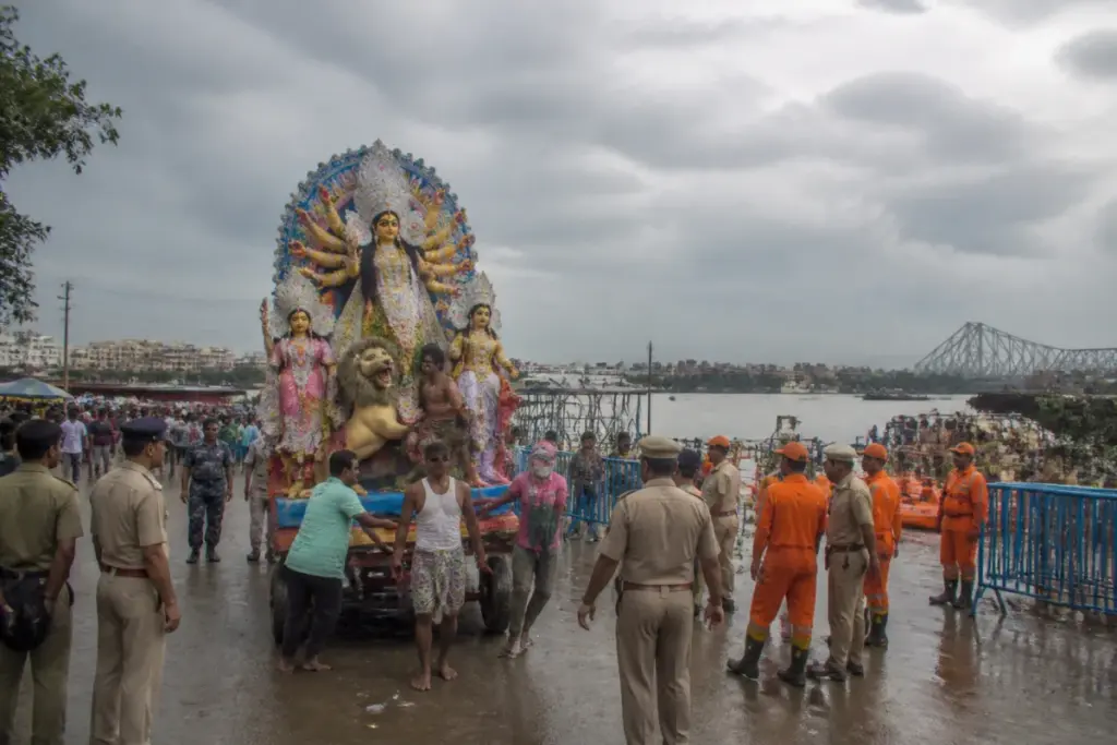 Kolkata idol immersion preparations at a river ghat with police, boats and workers