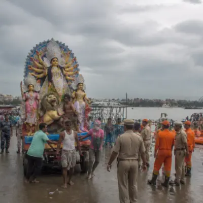Kolkata idol immersion preparations at a river ghat with police, boats and workers
